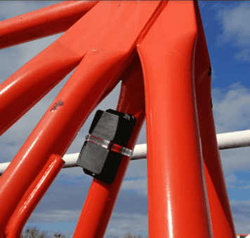 Capteur GPS Abeeway industriel sur structure orange robuste.