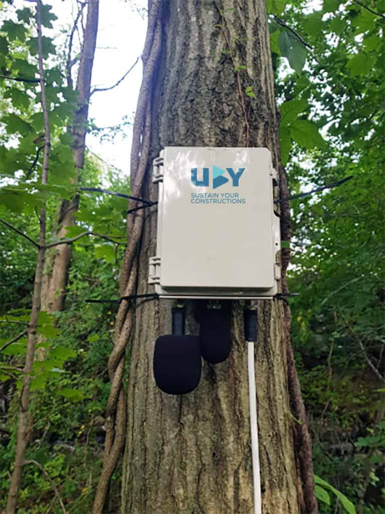 Capteur sonore multisource installé sur un arbre en forêt pour la surveillance environnementale.