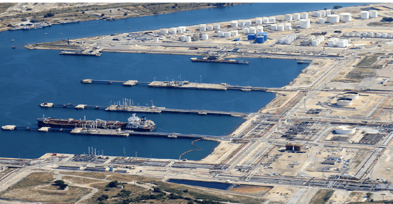 Bassin portuaire avec passerelles et infrastructures industrielles à proximité.