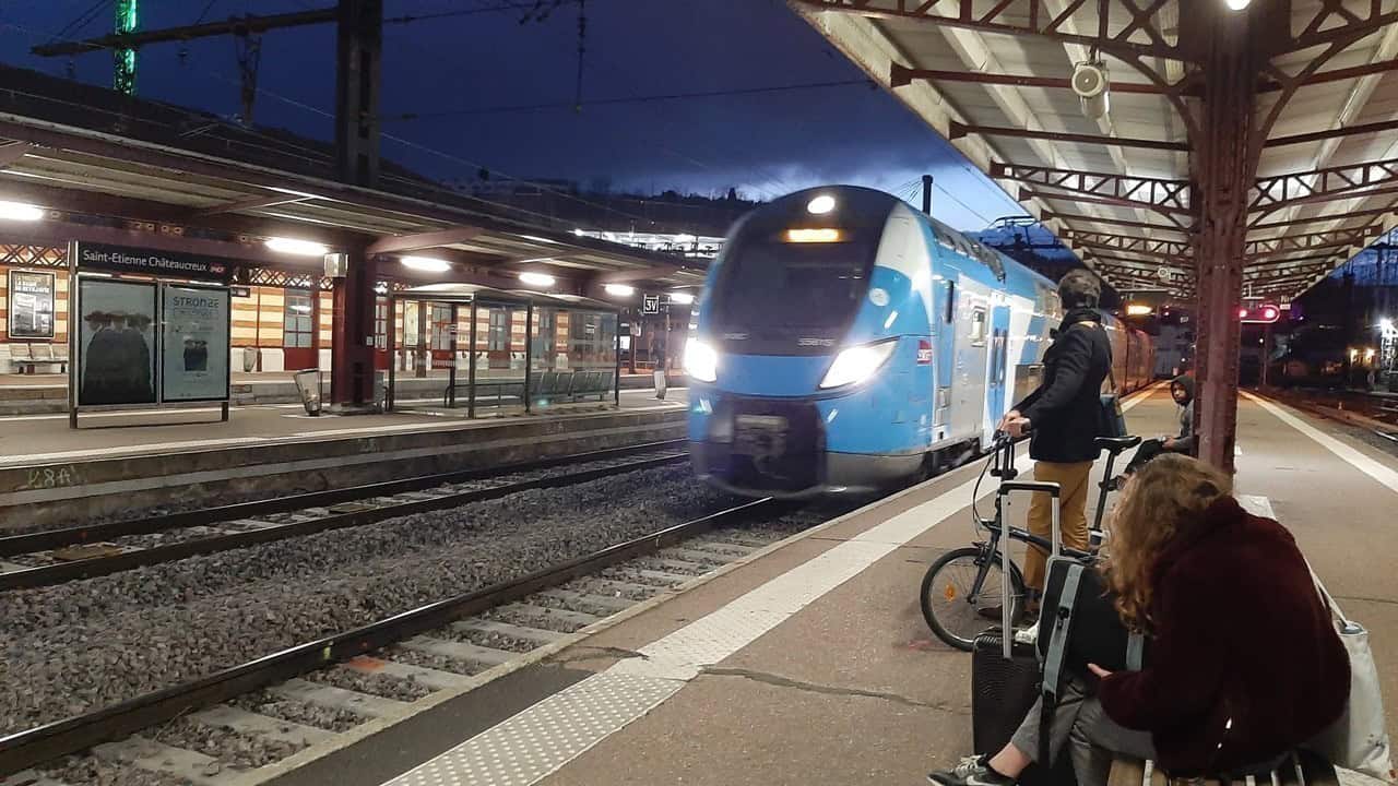 TGV moderne à la gare de Saint-Etienne, voyageurs attendant le train en soirée.