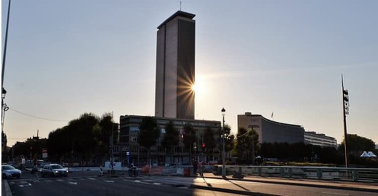 Tour des archives de Rouen, bâtiment moderne avec soleil derrière, situé dans le centre-ville histor.