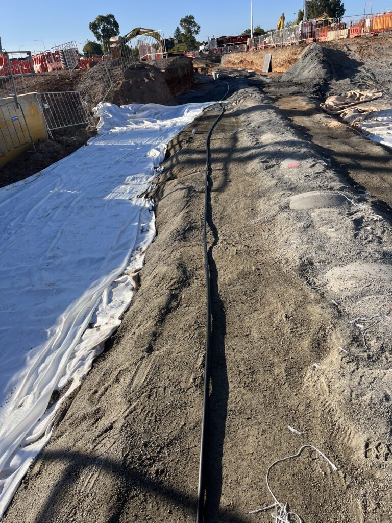 Construction site with geotextile (left) that will cover ASP (center) and the utility pipe (right)